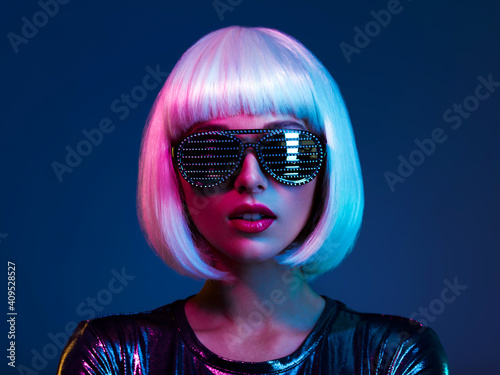 Stylish blonde in shiny dress and sunglasses with stresses. Closeup face  of beautiful  fashionable woman in white wig. Art portrait  of  an young attractive model. Fantasy style. Glamour fashion girl