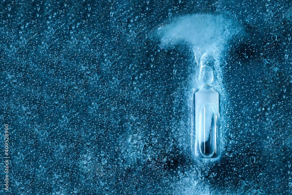Obraz premium glass ampoule with corona virus vaccine filled with medicinal liquid of pharmaceutical origin on frozen ice top view, close-up of the drug on a medical theme.