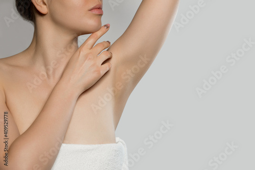 Armpit epilation  lacer hair removal. Young woman holding her arms up and showing clean underarms  depilati on smooth clear skin .Beauty portrait. Skin care.