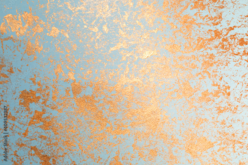 Texture of gold paint on blue paper