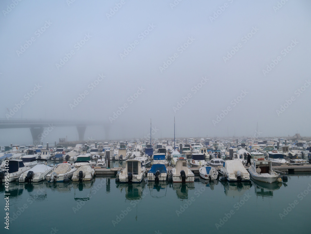 Boats in the fog in the bay of Cadiz capital, Andalusia. Spain. Europe.
