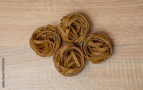 Raw whole grain brown pasta Tagliatelle, made with wheat flour, rich in nutrients: protein, carbohydrates and fiber