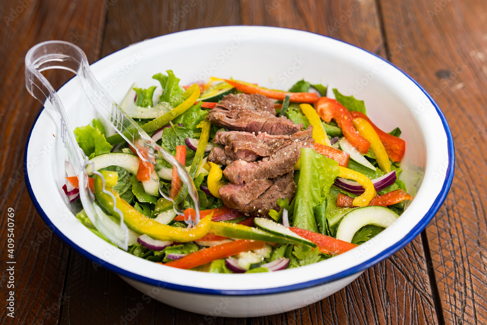 mixed garden salad with red onion, bell peppers, zucchini and steak