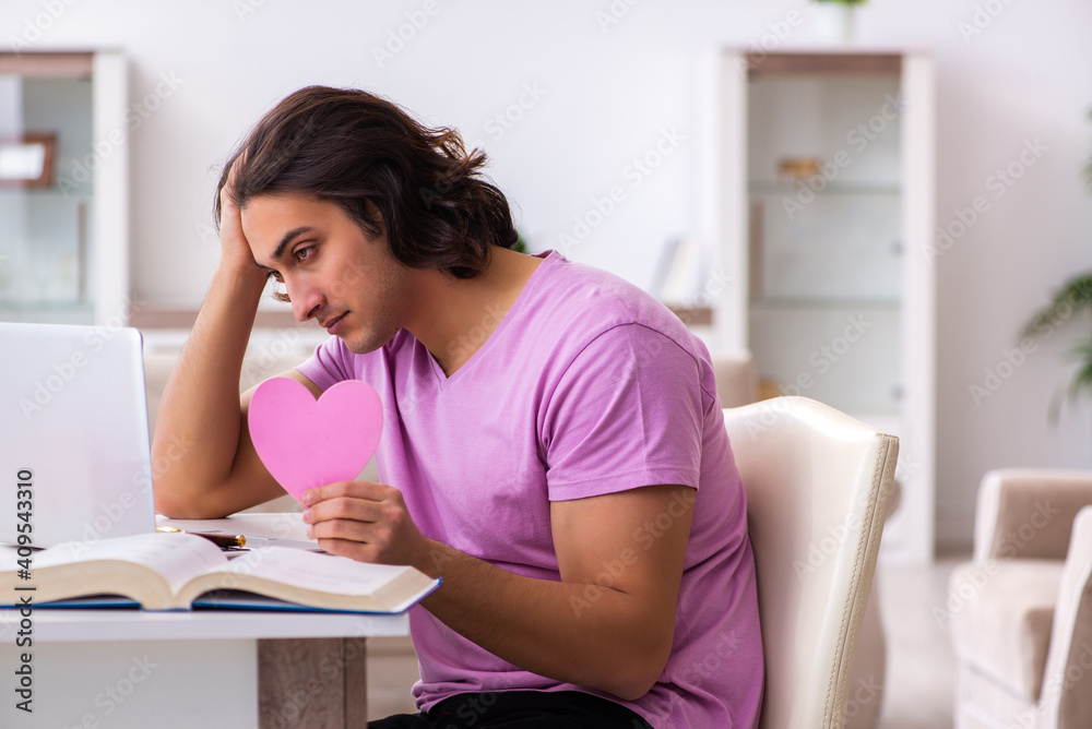 Male student in love preparing for exams at home Male student in love preparing for exams at home
