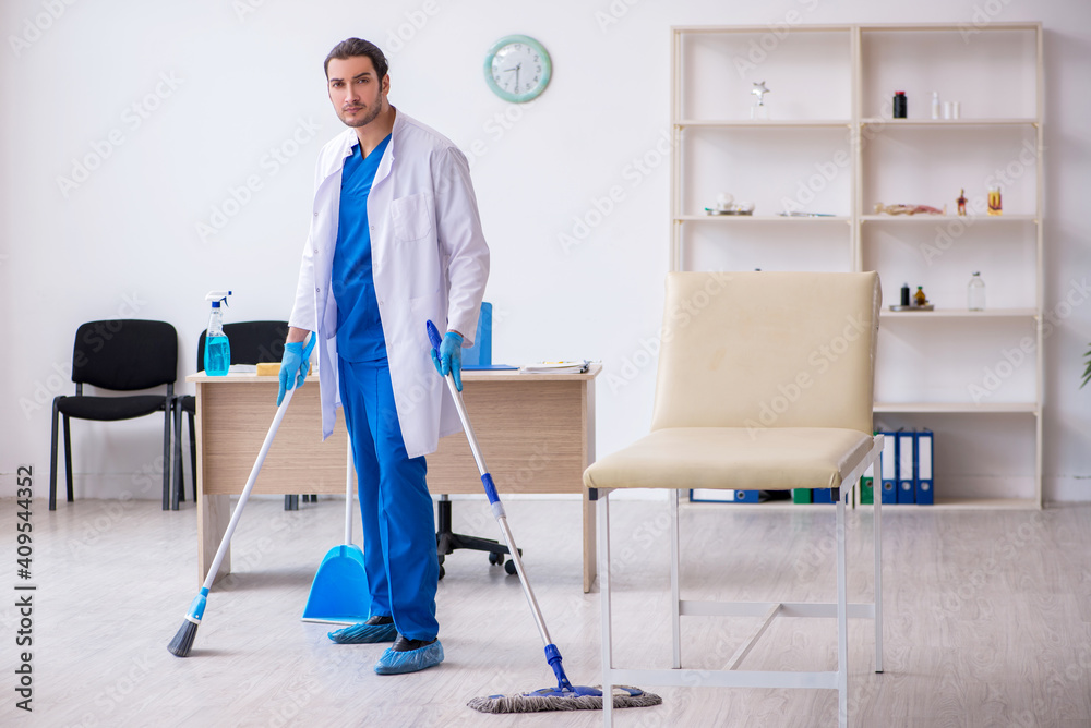 Young male contractor disinfecting clinic in pandemic concept Young male contractor disinfecting clinic in pandemic concept