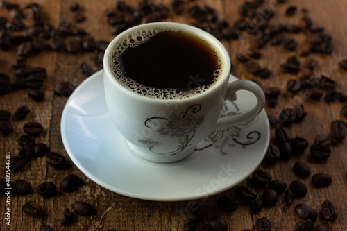 Closeup of Typical Brazilian Coffee Cup and Coffee Beans on a Wooden Table