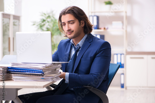 Young male employee unhappy with excessive work