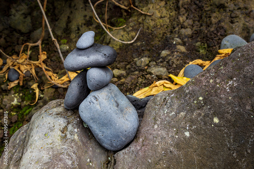 Peaceful stack of black rocks, balanced in the crevice of another rock. Zen stone balancing in Black Rock Beach, Maui, Hawaii