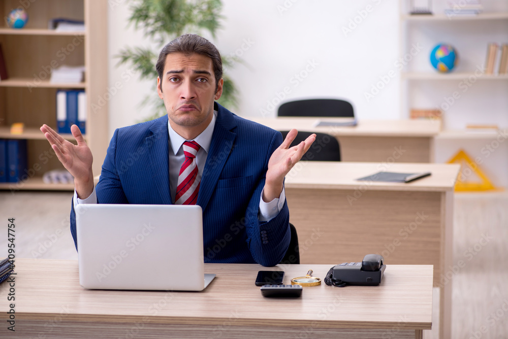 Young male employee sitting in the office Young male employee sitting in the office