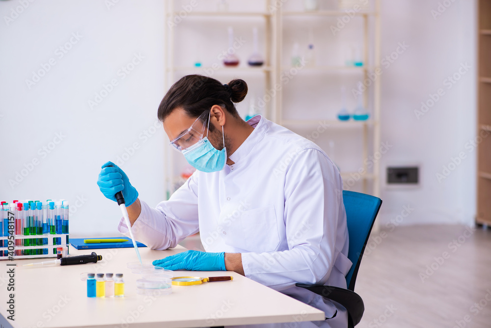 Young male chemist working in the lab Young male chemist working in the lab