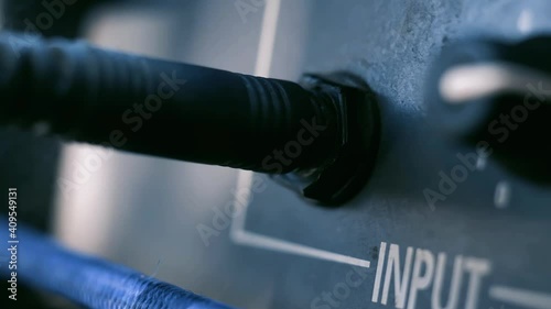 Man Hand connecting Jack Audio plug-in into the Guitar Amplifier Outdoors. Close Up. 4K Resolution.