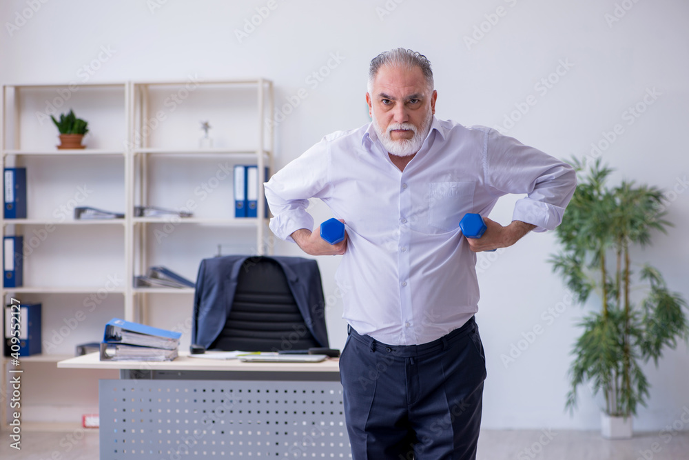 Aged male employee doing physical exercises during break Aged male employee doing physical exercises during break