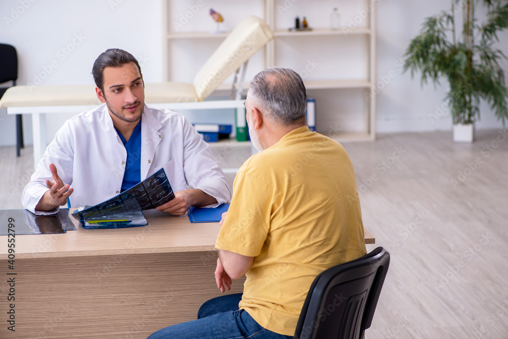 Old patient visiting young male doctor radiologist Old patient visiting young male doctor radiologist