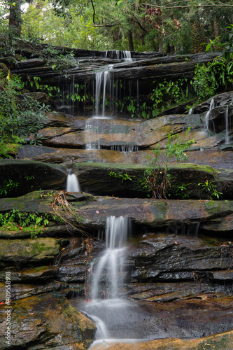 Small rocky cascade waterfall with little water.