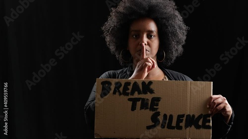 finger on mouth female protester holding break the silence cardboard sign photo