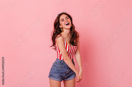 Fotografie Charming slim woman in striped top emotionally laughs