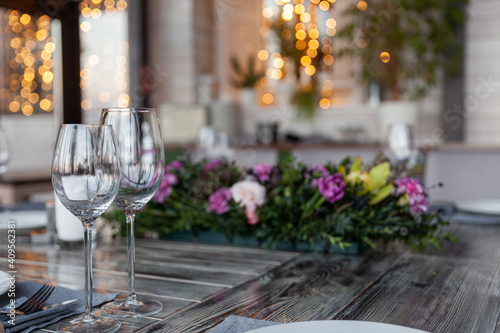 Modern veranda restaurant interior  flowers  banquet setting  glasses  plates