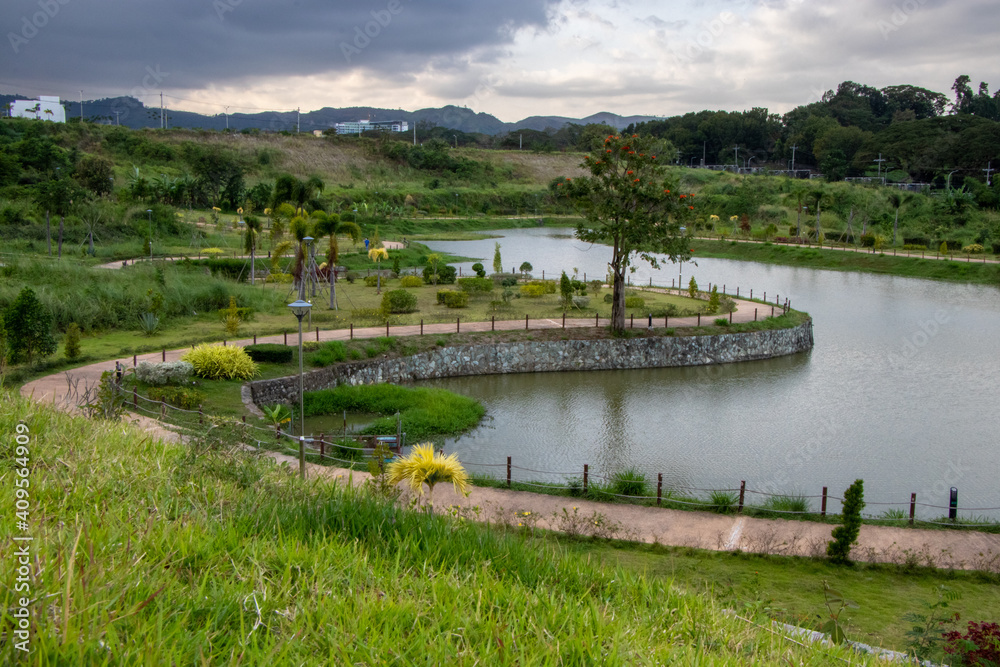 Curved Pedestrian Path in Lush Tropical Park next to Large Pond - Clark, Pampanga, Luzon, Philippines