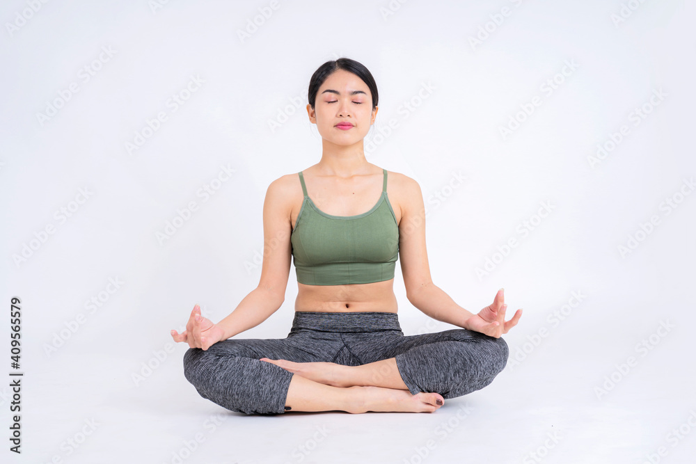 Attractive Asian woman practicing yoga sitting in Padmasana exercise pose, lotus pose during exercise meditation Attractive Asian woman practicing yoga sitting in Padmasana exercise pose, lotus pose during exercise meditation