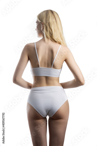 Model stands with her back to the camera in her underwear