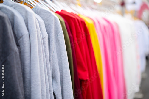 A brightly colored lean sweater hung on a hanger in a clothing store © jittawit.21