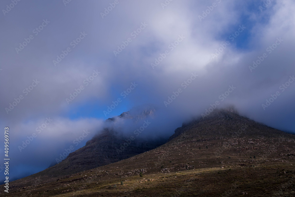 Soft misty clouds roll in over a small mountain image for background use Soft misty clouds roll in over a small mountain image for background use