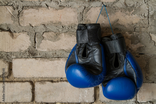 A pair of leather boxing gloves. Sports equipment on a brick wall background.
