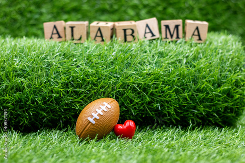 Football with Alabama sign on green grass photo
