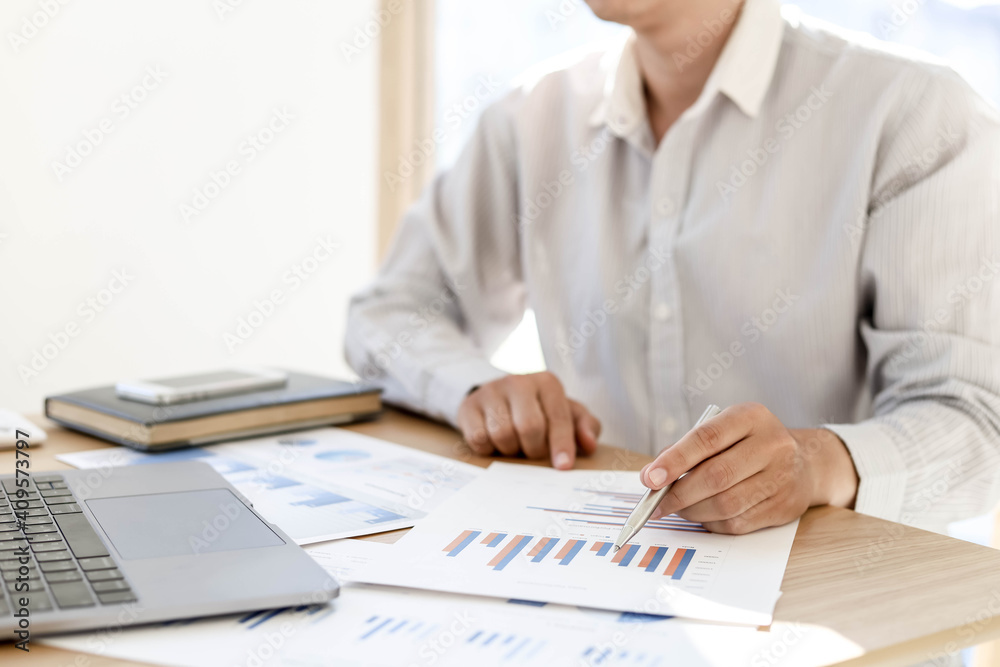 Businessman is reading monthly sales summary of each salesperson. He sits and works in his private office. Sales management concept. Businessman is reading monthly sales summary of each salesperson. He sits and works in his private office. Sales management concept.