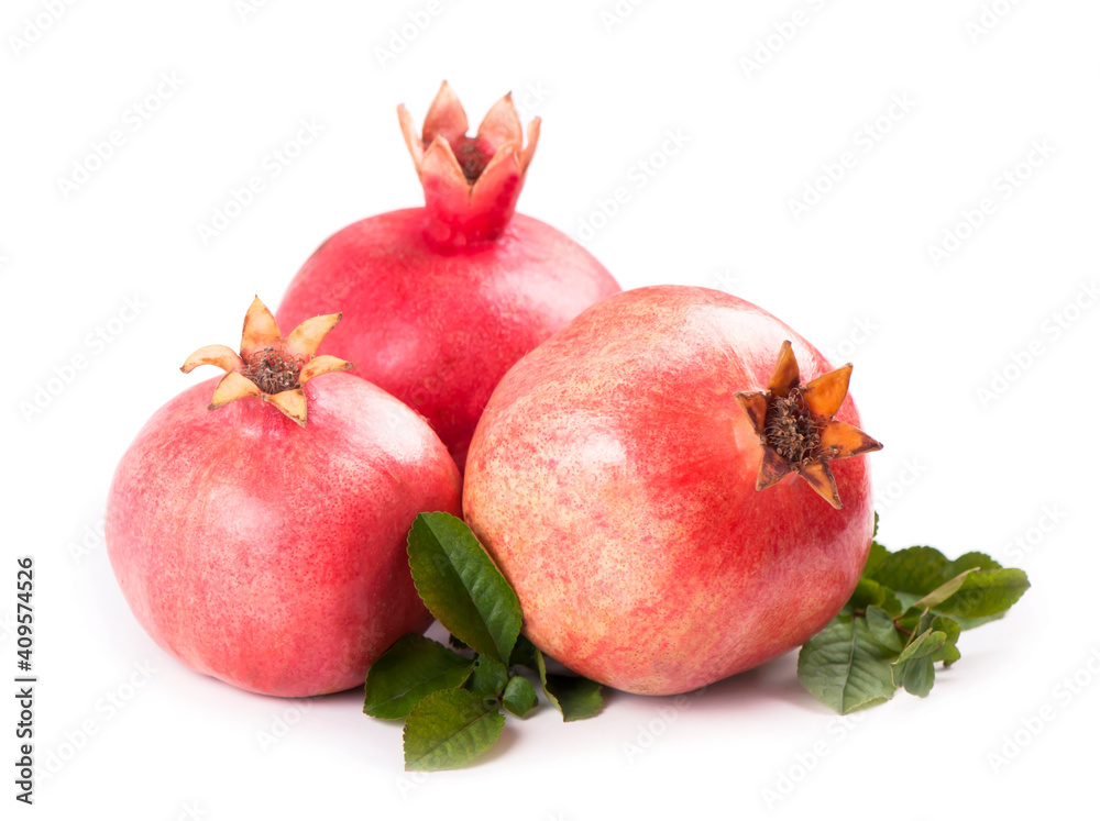 Ripe pomegranates with pomegranate leaves isolated on a white Ripe pomegranates with pomegranate leaves isolated on a white