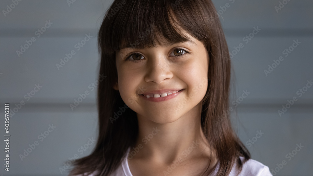 Head shot portrait close up cute little girl with healthy smile standing on grey wooden wall studio background isolated, adorable preschool kid child looking at camera, feeling happy and positive Head shot portrait close up cute little girl with healthy smile standing on grey wooden wall studio background isolated, adorable preschool kid child looking at camera, feeling happy and positive