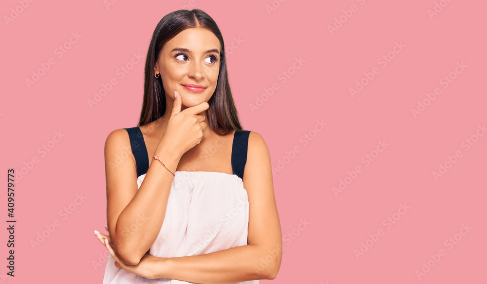 Young hispanic woman wearing casual clothes with hand on chin thinking about question, pensive expression. smiling with thoughtful face. doubt concept. Young hispanic woman wearing casual clothes with hand on chin thinking about question, pensive expression. smiling with thoughtful face. doubt concept.