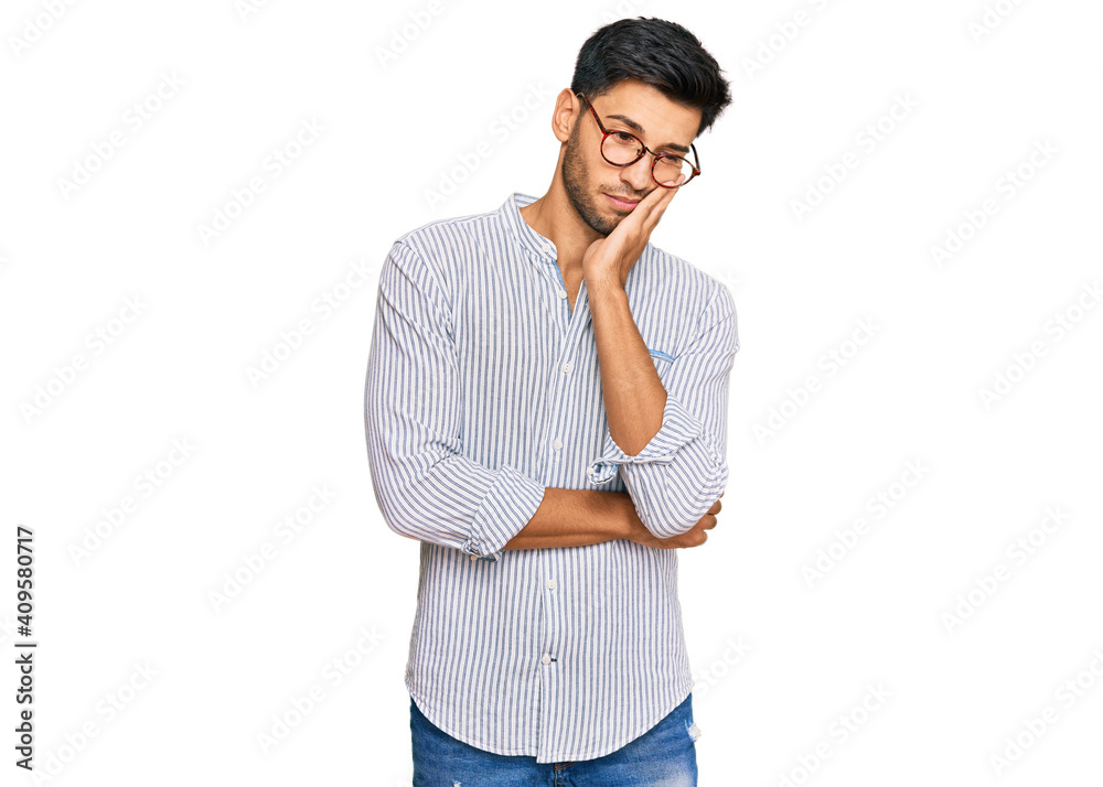 Young handsome man wearing casual clothes and glasses thinking looking tired and bored with depression problems with crossed arms. Young handsome man wearing casual clothes and glasses thinking looking tired and bored with depression problems with crossed arms.