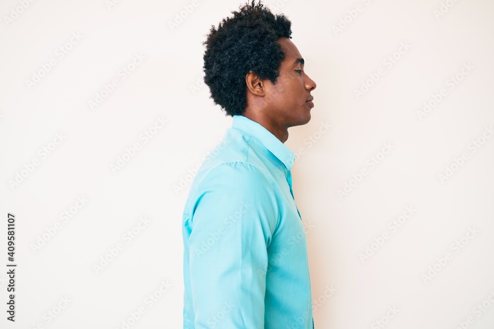 Handsome african american man with afro hair wearing casual clothes looking to side, relax profile pose with natural face with confident smile. Handsome african american man with afro hair wearing casual clothes looking to side, relax profile pose with natural face with confident smile.