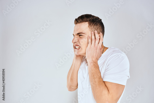 Man in white t-shirt displeased facial expression gesturing with hands studio lifestyle