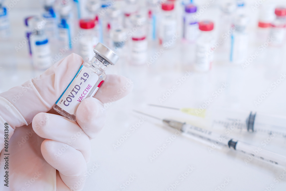 Doctor hand in medical glove hold bottle of Coronavirus vaccine bottle , Vaccination and immunization to protect patient from flu ,disease and covid-19 ,selective focus Doctor hand in medical glove hold bottle of Coronavirus vaccine bottle , Vaccination and immunization to protect patient from flu ,disease and covid-19 ,selective focus