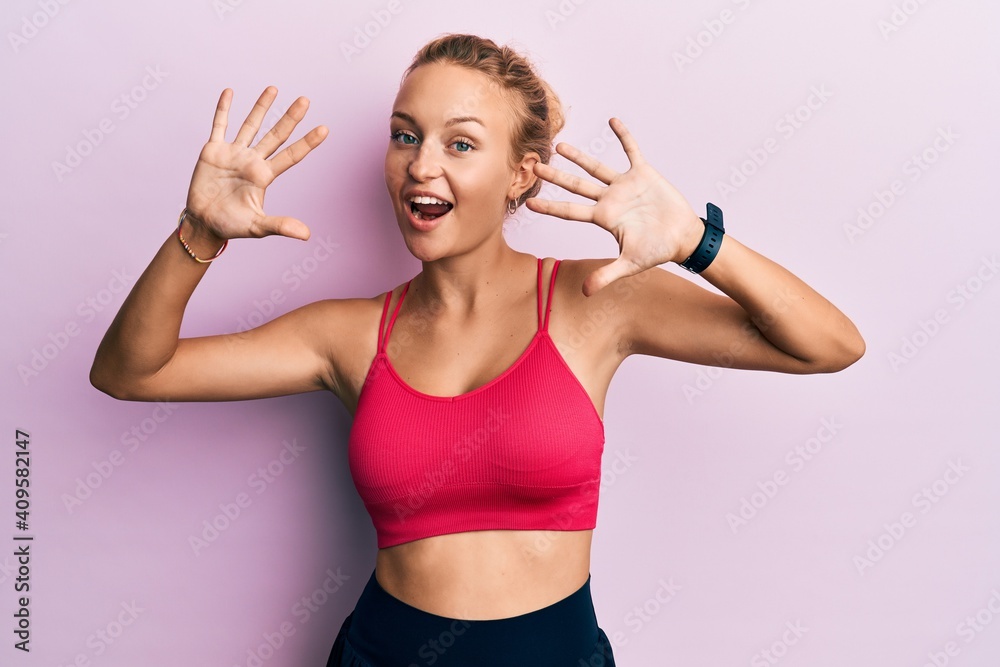 Beautiful caucasian woman wearing sportswear showing and pointing up with fingers number ten while smiling confident and happy. Beautiful caucasian woman wearing sportswear showing and pointing up with fingers number ten while smiling confident and happy.