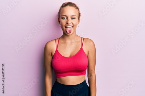 Beautiful caucasian woman wearing sportswear sticking tongue out happy with funny expression. emotion concept. © Krakenimages.com