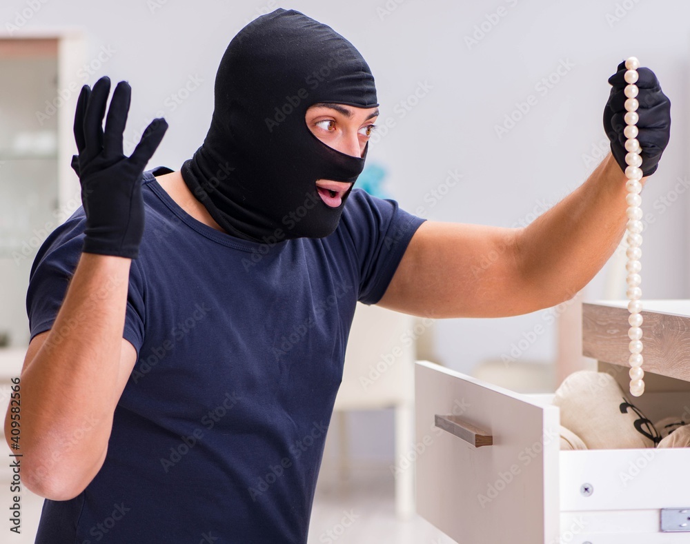 Robber wearing balaclava stealing valuable things Robber wearing balaclava stealing valuable things