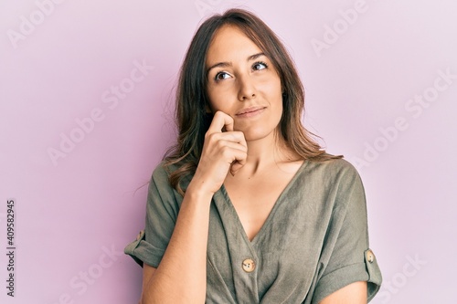 Young brunette woman wearing casual clothes thinking concentrated about doubt with finger on chin and looking up wondering © Krakenimages.com
