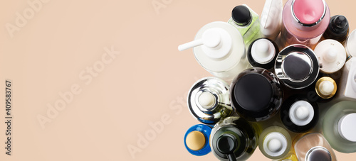 Many cosmetics tubes top view banner on biege skin tone background, copy space.