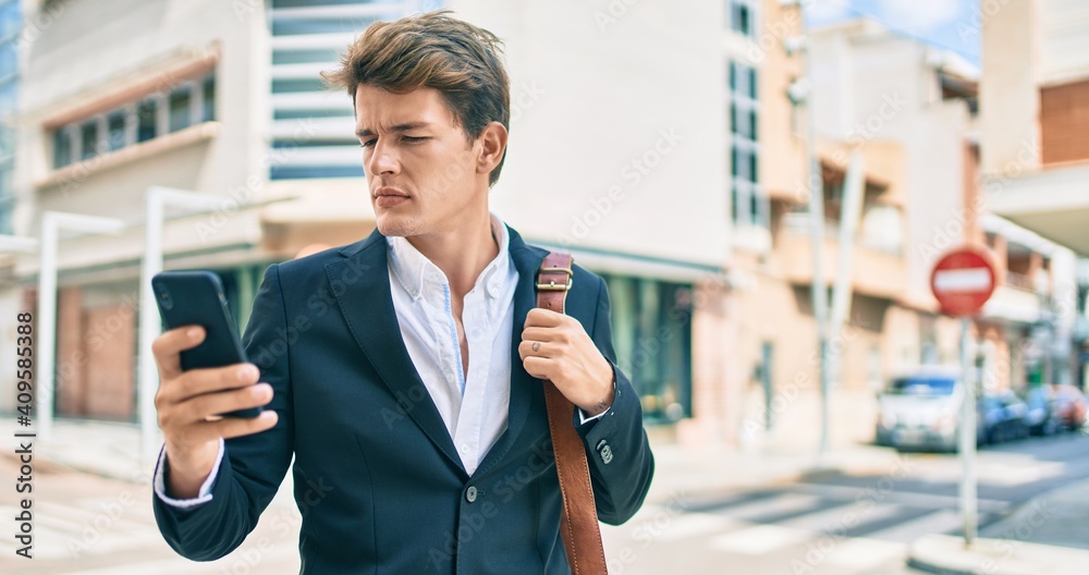 Young caucasian businessman with serious expression using smartphone at the city. Young caucasian businessman with serious expression using smartphone at the city.