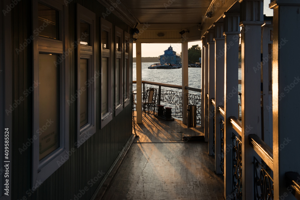 Table and chairs in a cafe on the river embankment on a summer evening at sunset Table and chairs in a cafe on the river embankment on a summer evening at sunset