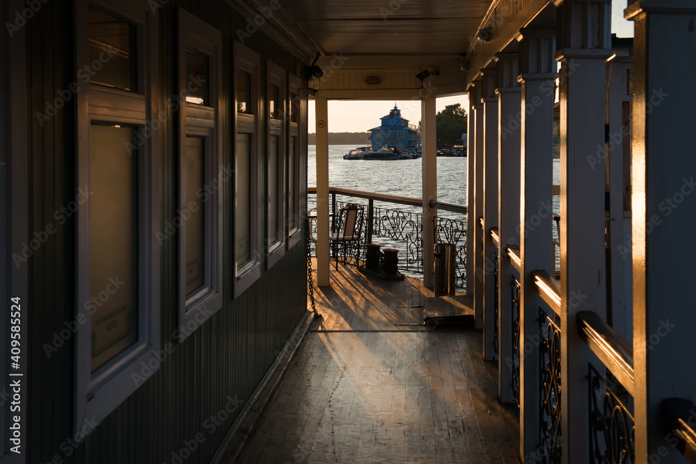 Table and chairs in a cafe on the river embankment on a summer evening at sunset