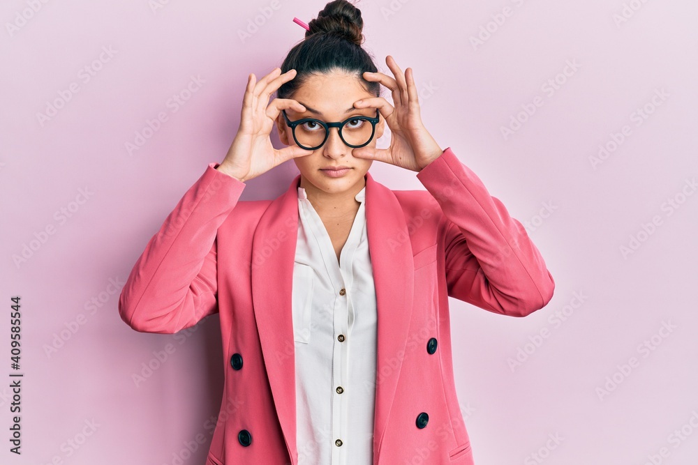 Beautiful middle eastern woman wearing business jacket and glasses trying to open eyes with fingers, sleepy and tired for morning fatigue