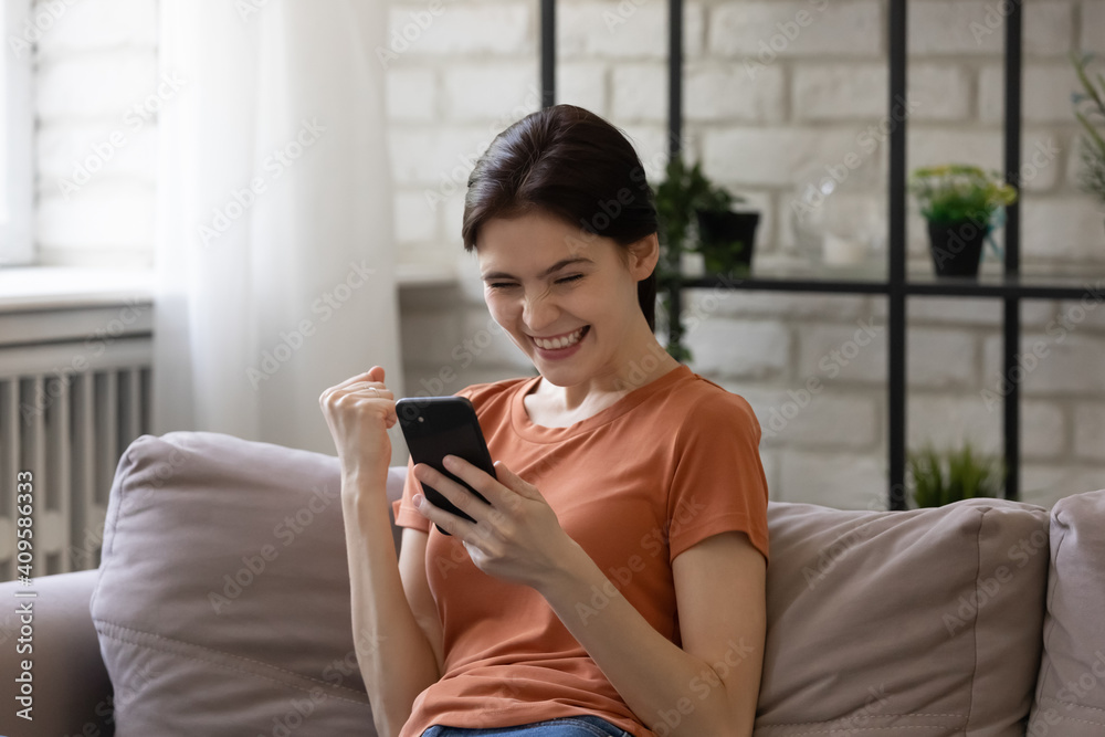 Overjoyed woman looking at phone screen, celebrating success, showing yes gesture, excited satisfied young female holding smartphone, reading good news in message, lottery win, shopping offer Overjoyed woman looking at phone screen, celebrating success, showing yes gesture, excited satisfied young female holding smartphone, reading good news in message, lottery win, shopping offer