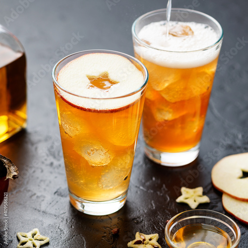 Ginger Beer and Honey Whiskey cocktail with ice cubes and red apple slices. 