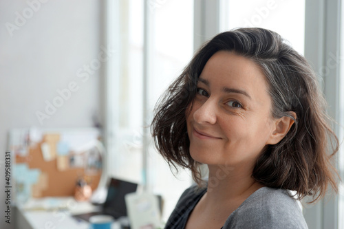 Portrait of 38 year old woman against home office background