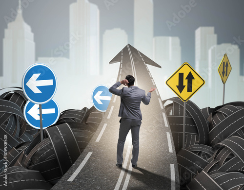 Businessman in uncertainty concept on road intersection crossroa photo