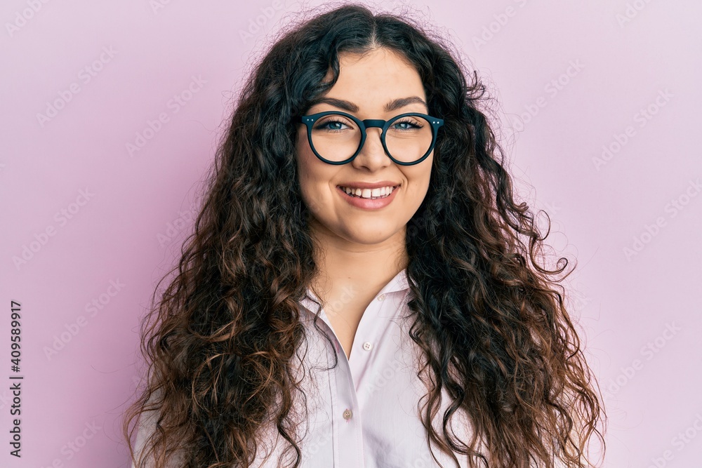 Obraz premium Young brunette woman with curly hair wearing casual clothes and glasses with a happy and cool smile on face. lucky person.